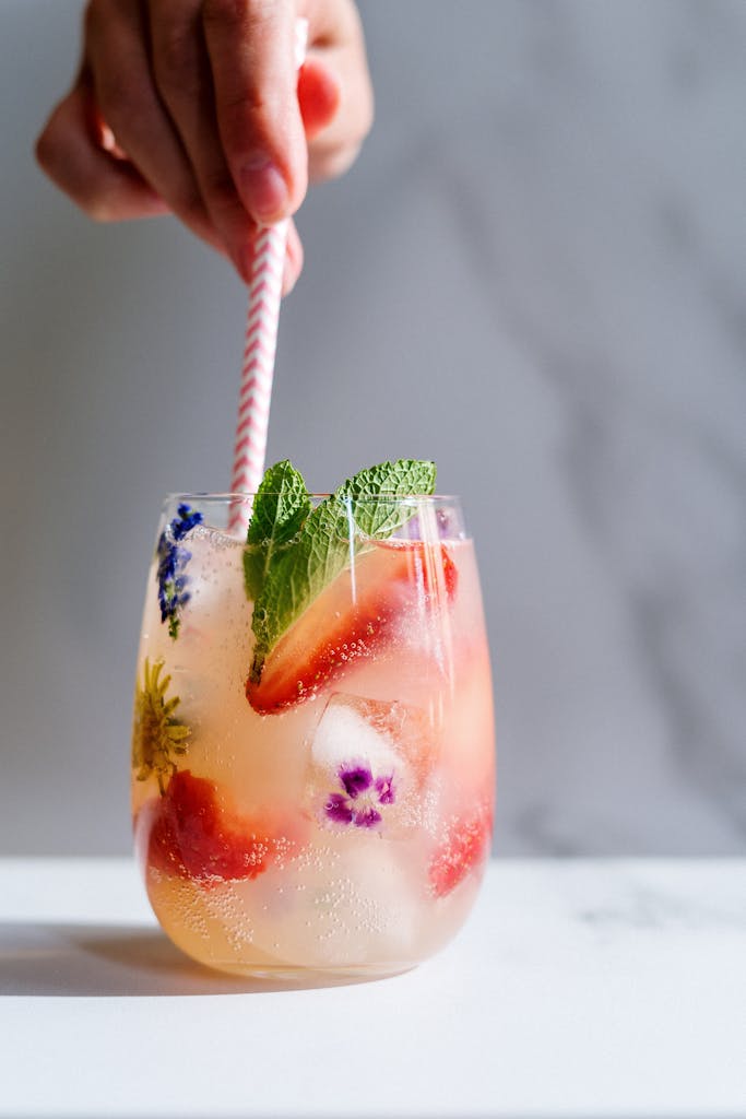 Person Holding Straw on a Cocktail